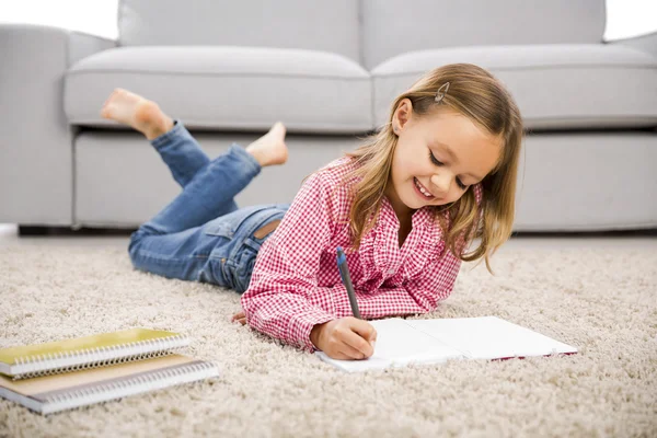 En liten flicka som gör läxor — Stockfoto
