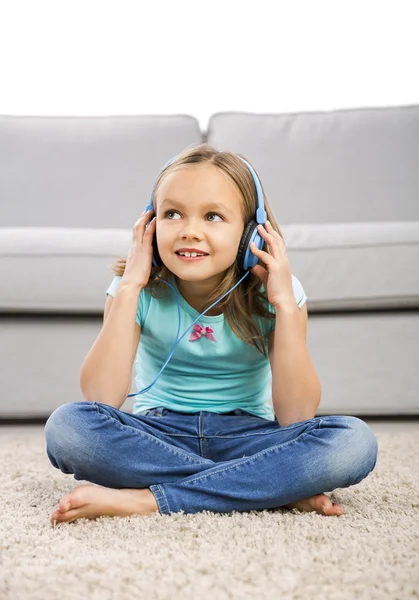 Roztomilá dívka poslouchat hudbu se sluchátky — Stock fotografie