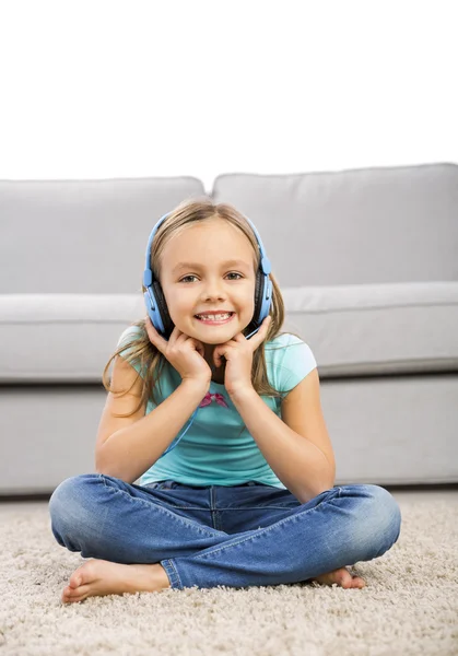 Roztomilá dívka poslouchat hudbu se sluchátky — Stock fotografie