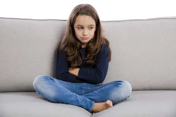 Niña sentada en un sofá — Foto de Stock