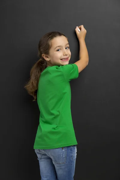 Menina escrevendo em um quadro negro — Fotografia de Stock