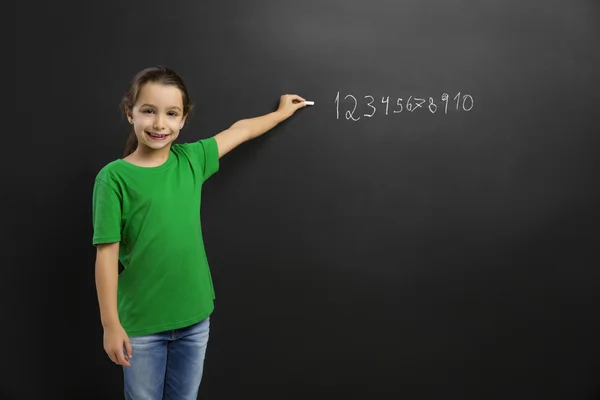 Meisje in een schoolbord schrijven — Stockfoto