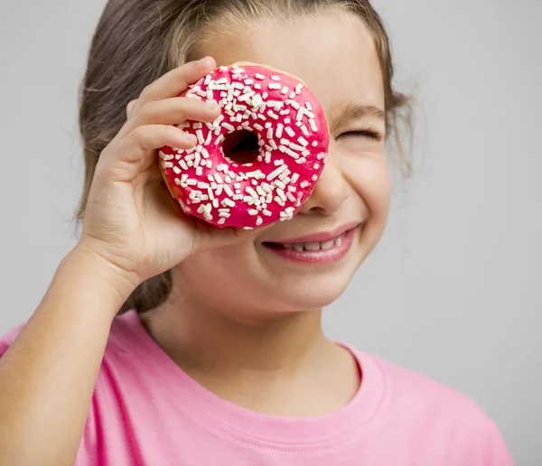 Menina olhando através de um donut — Fotografia de Stock