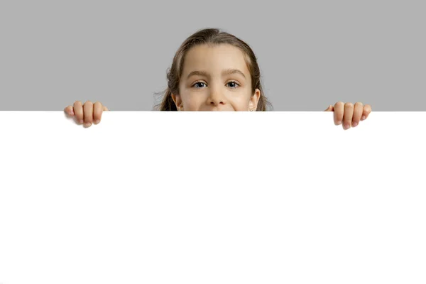 Cute girl holding a blankboard — Stock Photo, Image