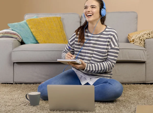 Donna che studia ascoltando musica — Foto Stock