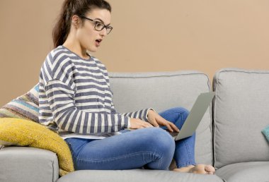 Evde dizüstü bilgisayarla çalışan kadın.