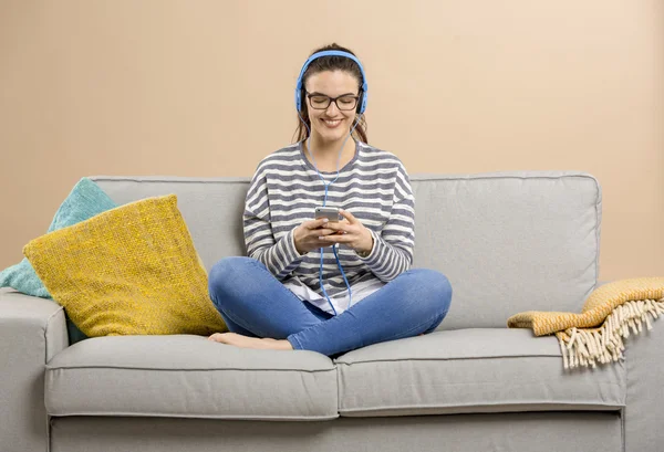 Mulher no sofá ouvindo música — Fotografia de Stock