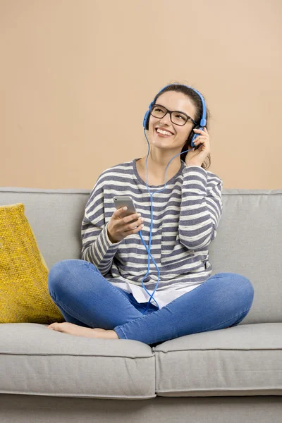 Femme sur canapé écouter de la musique — Photo