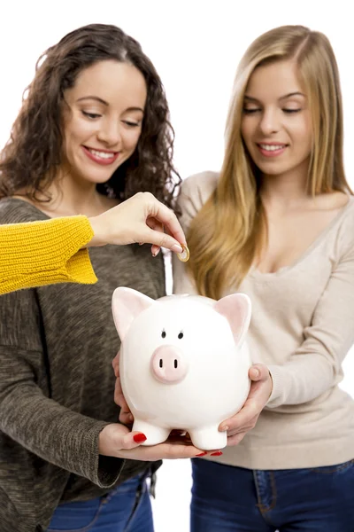 Teenage friends holding a piggy-bank — Stock Photo, Image