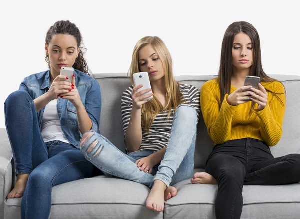 Девушки-подростки дома с помощью мобильных телефонов — стоковое фото