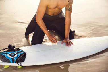 surfer sörf için hazırlanıyor