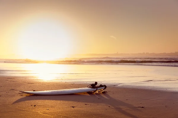 Paisaje de playa con una tabla de surf — Foto de Stock