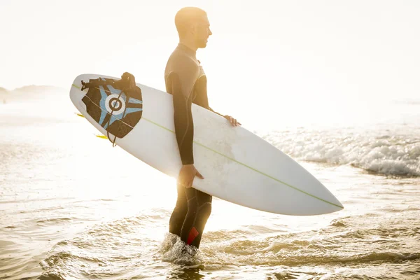 Surfer with surfboard at beach — Stock Photo, Image