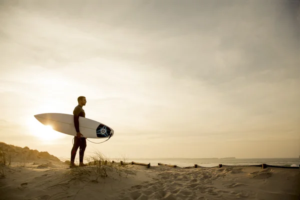 Surfare med surfbräda ser att vågor — Stockfoto