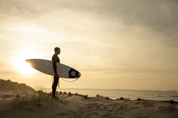 Surfare med surfbräda ser att vågor — Stockfoto
