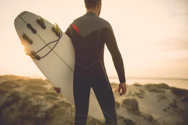 Surfer mit Surfbrett blickt auf Wellen — Stockfoto