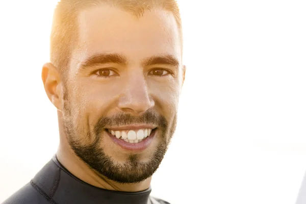 Handsome young surfer smiling — Stock Photo, Image