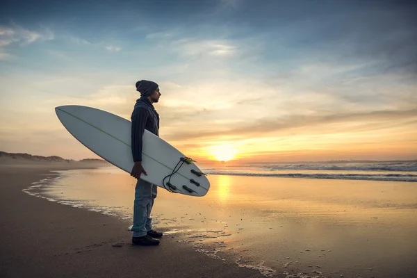 Surfer mit Surfbrett blickt auf Wellen — Stockfoto