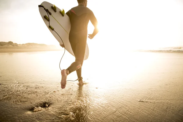 Surfista com prancha correndo para ondas — Fotografia de Stock