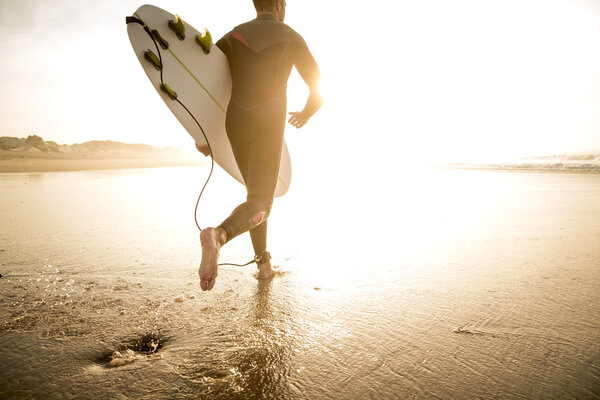 Surfer with surfboard running to waves — Stock Photo, Image