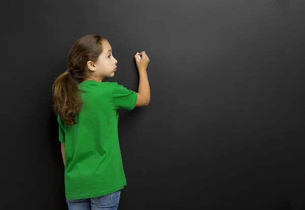 Meisje in een schoolbord schrijven — Stockfoto