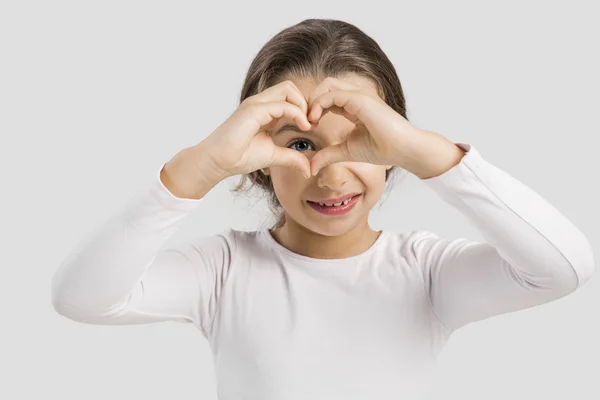 Mädchen blickt durch herzförmige Hände — Stockfoto