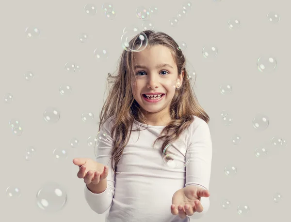 Девушка играет с мыльными пузырями — стоковое фото