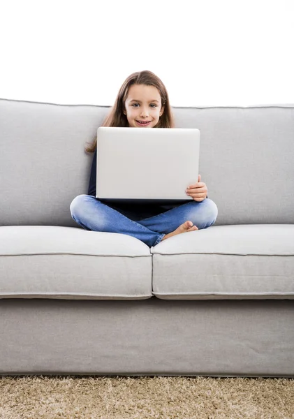 Kleines Mädchen auf der Couch arbeitet am Laptop — Stockfoto