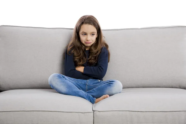 Girl sitting on couch upset — Stock Photo, Image