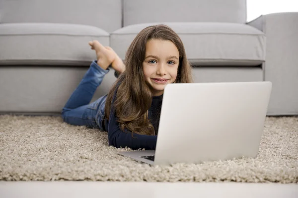 Flicka hemma arbetar med en bärbar dator — Stockfoto