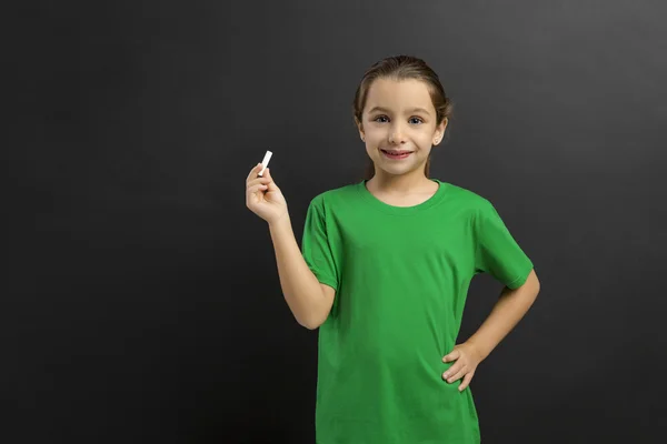 Little girl writing in blackboard — Stock Photo, Image