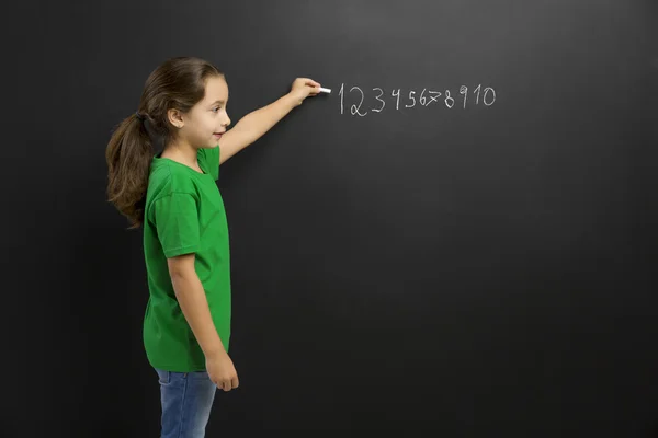 Klein meisje in schoolbord schrijven — Stockfoto