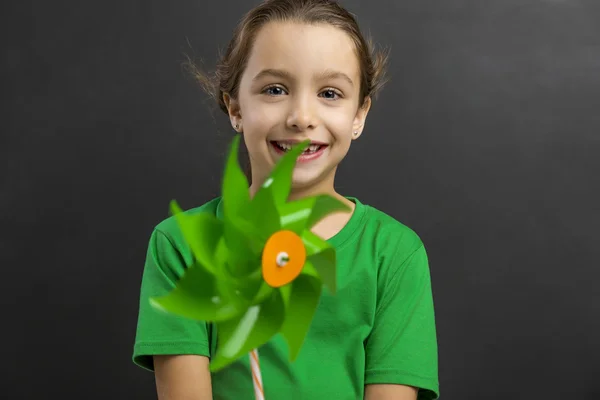 Meisje glimlachend en houden van windmolen — Stockfoto