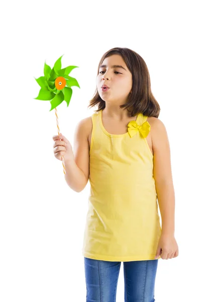 Girl blowing a plastic windmill — Stock Photo, Image