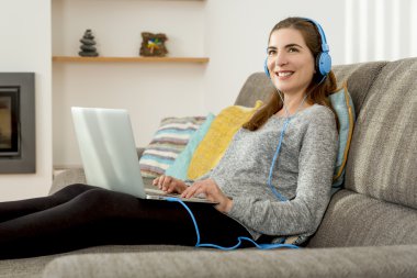 Müzik dinleme ve dizüstü kullanan kadın