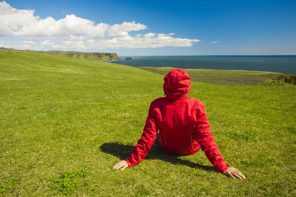 Mulher sentada na grama apreciando a natureza — Fotografia de Stock