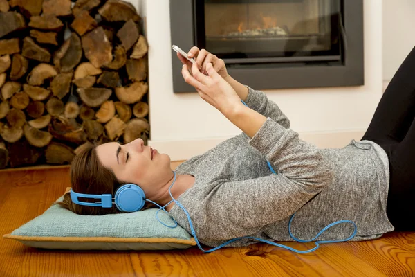 Donna sdraiata sul pavimento e ascoltare musica — Foto Stock