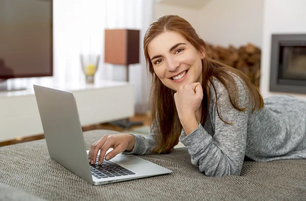 Mulher ouvindo música e usando laptop — Fotografia de Stock