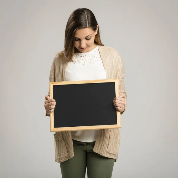 一个漂亮而快乐的女人拿着黑板 带着复制空间 — 图库照片