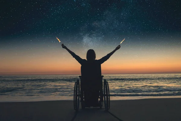 Инвалидная Женщина Инвалидном Кресле Держит Огненные Искры Ночью Пляже — стоковое фото
