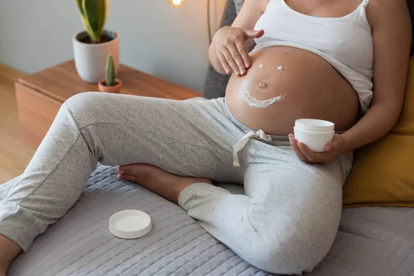 Gravid Kvinna Applicera Bristning Grädde Magen — Stockfoto