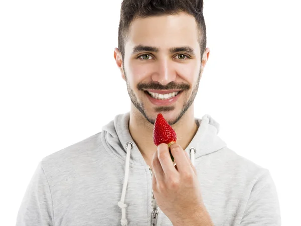 Happy young eating a strawberry — Stock Photo, Image