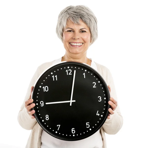 Mujer mayor sosteniendo un reloj — Foto de Stock