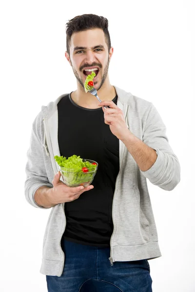 Jeune homme mangeant une salade — Photo