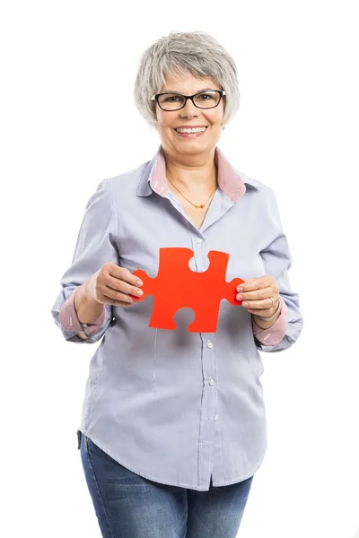 Oudere vrouw met een raadselstuk — Stockfoto