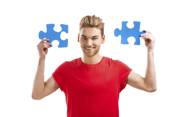 Young man holding  puzzle pieces — Stock Photo, Image