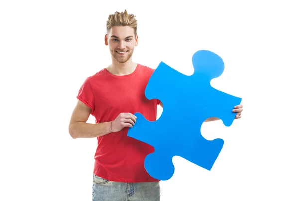 Young man holding a puzzle piece — Stock Photo, Image