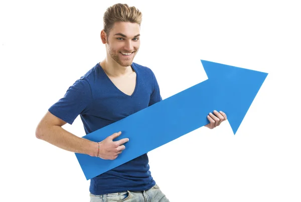 Young man holding a blue arrow — Stock Photo, Image