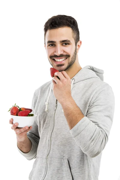 Happy young eating a strawberry — Stock Photo, Image
