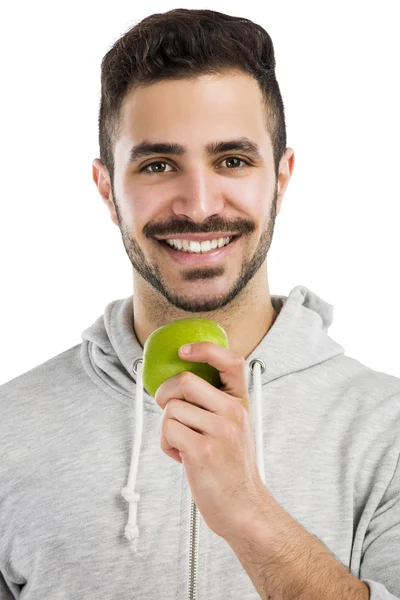 Mies maistaa vihreää tuoretta omenaa — kuvapankkivalokuva